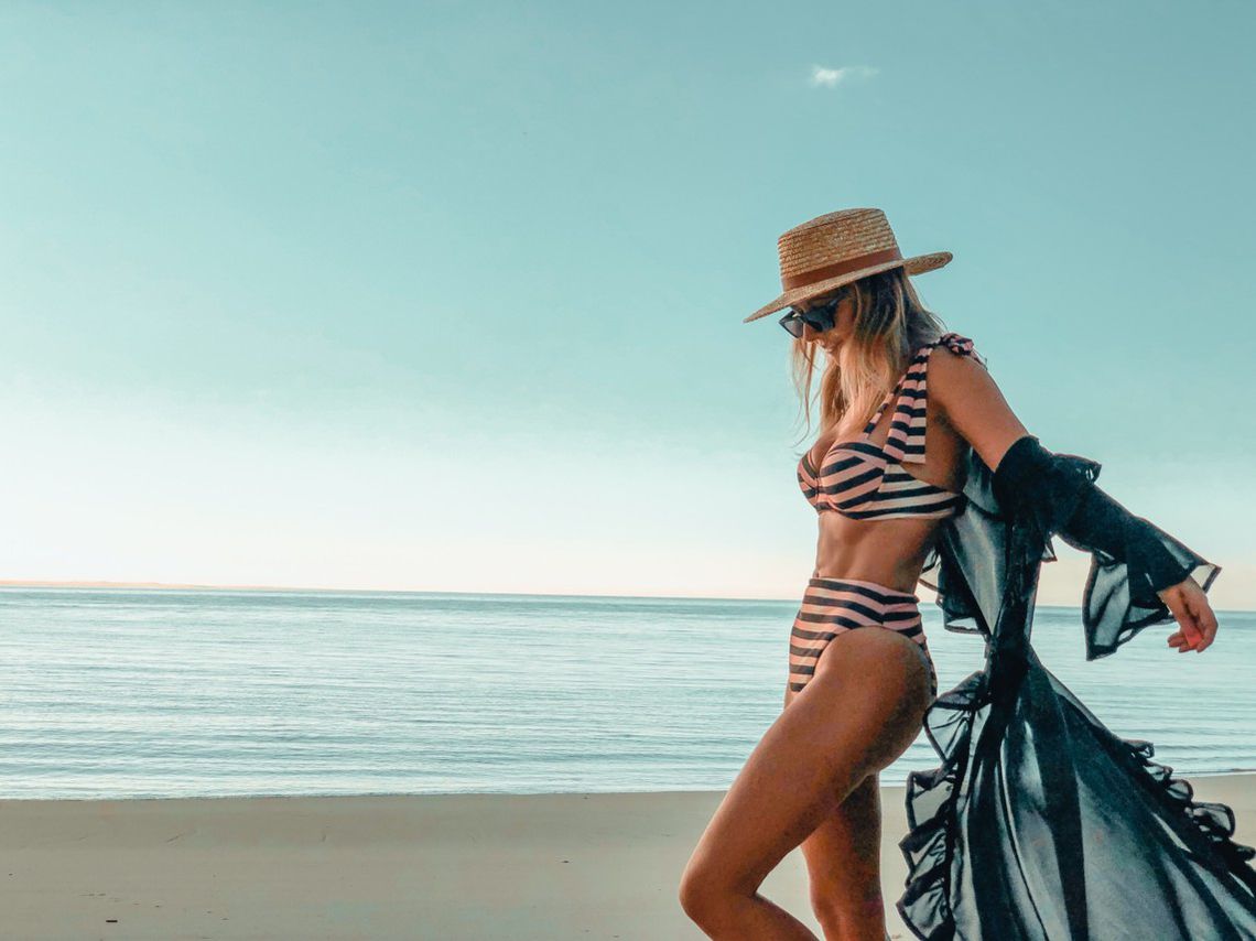 Woman at the beach with a hat and loose hair