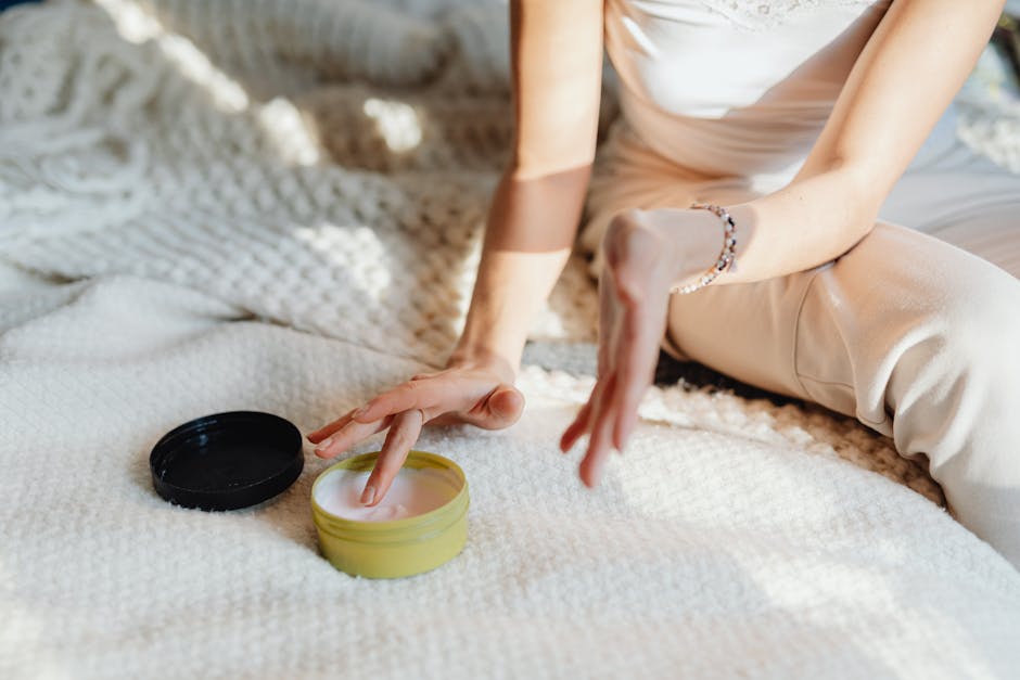 A woman gently applying face cream as part of her skincare routine.