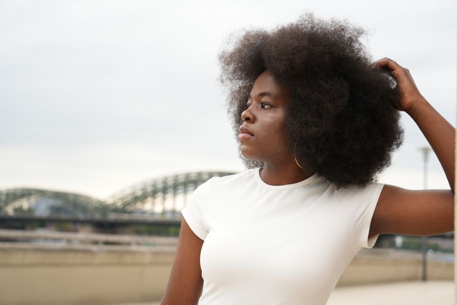 Captivating portrait of a woman with afro hair in Köln, showcasing elegance and style.