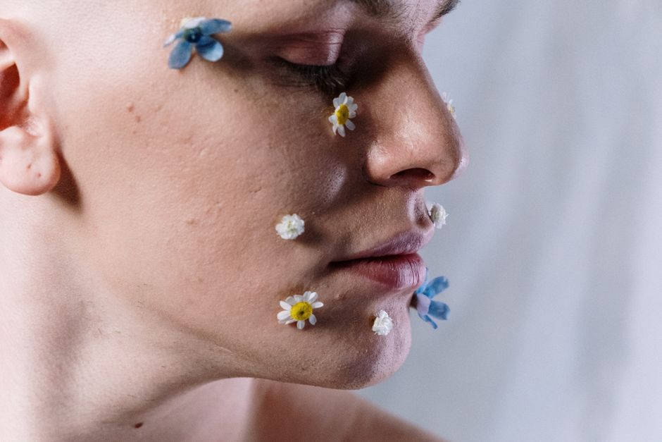 Artistic portrait highlighting floral makeup on a serene face, conveying beauty and creativity.