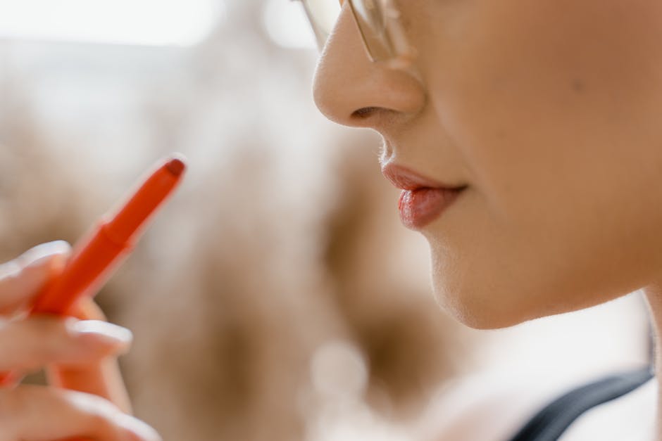 Close-up of a woman's lips and lipstick, highlighting beauty and cosmetics.