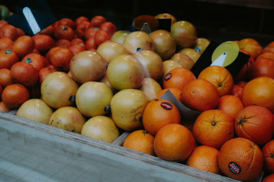 A vibrant array of oranges and apples at a market stall. Ideal for shopping and grocery themes.