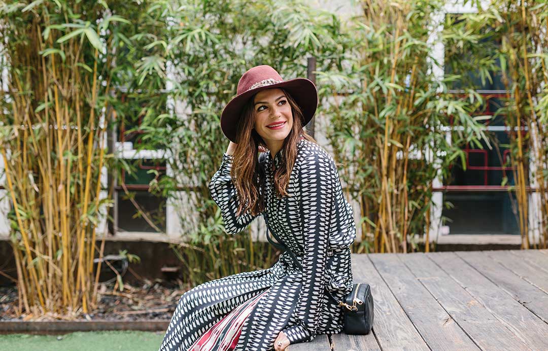 Woman outdoors wearing a hat with loose styled hair