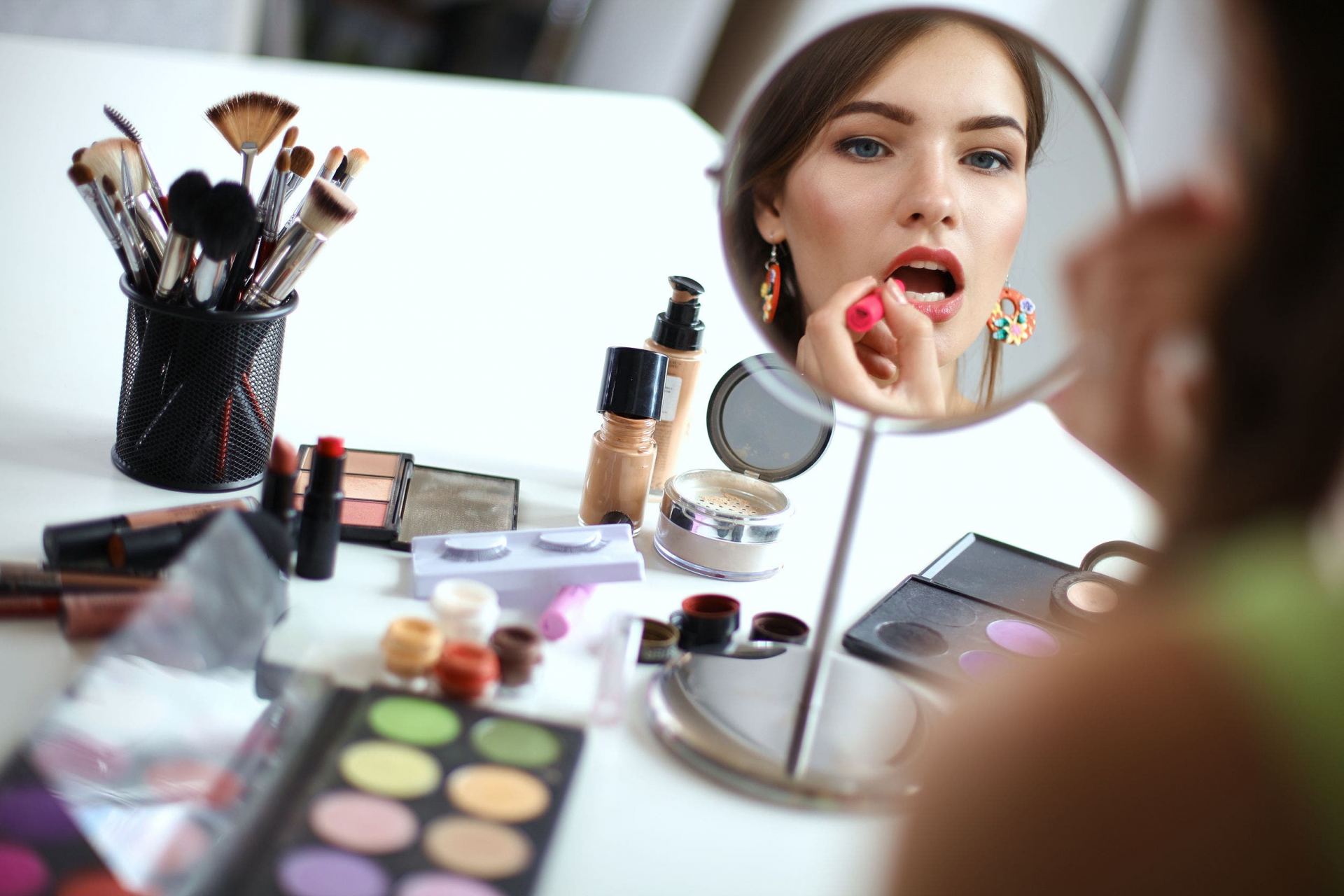 Woman applying makeup before adding accessories