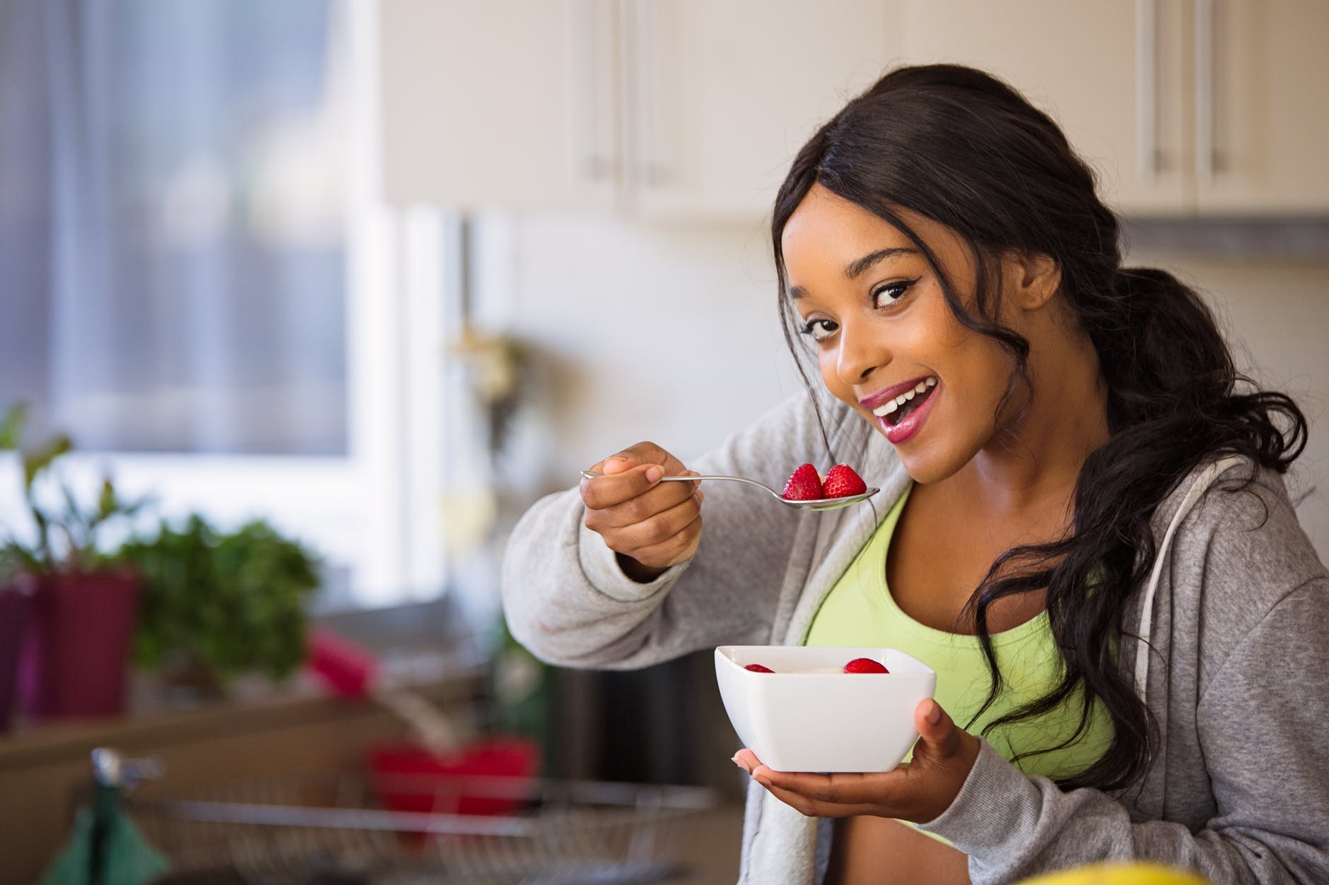 Woman enjoying strawberries with a fresh beauty look